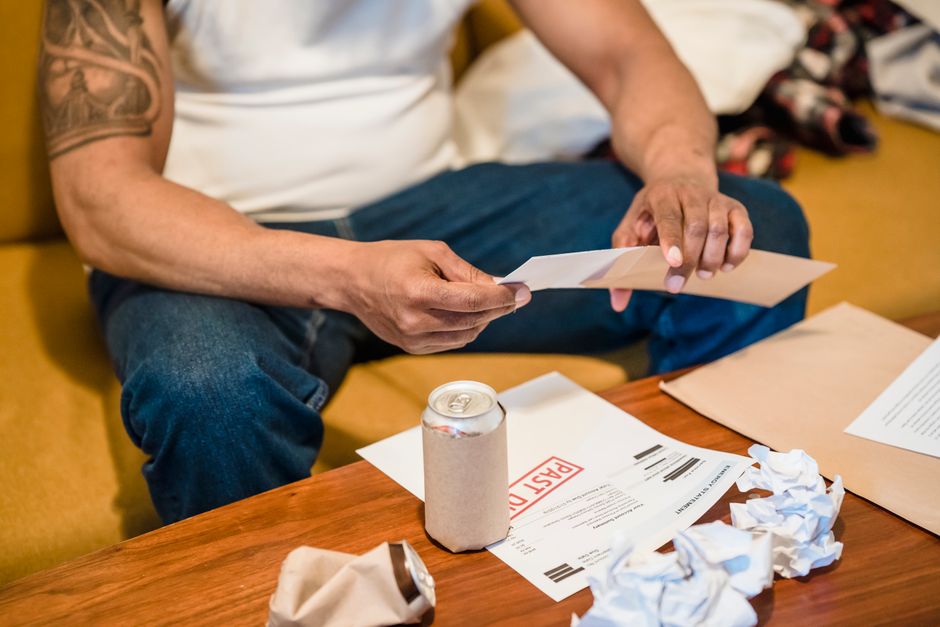 A person opening and sorting mail and envelopes at home